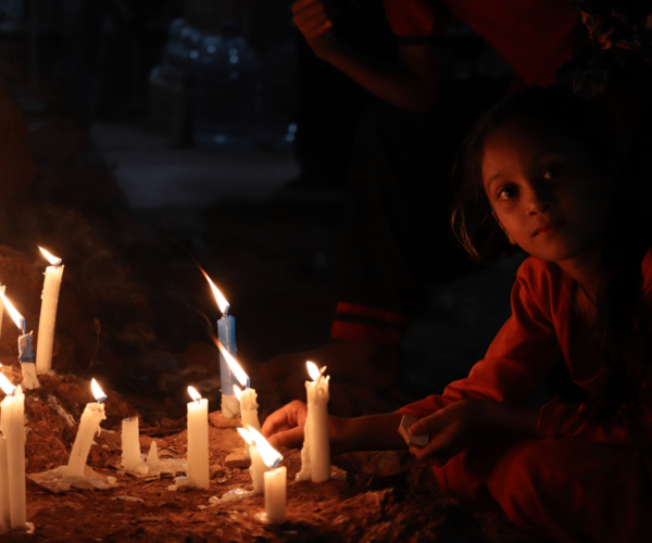 Indian girl sitting by candles in the dark