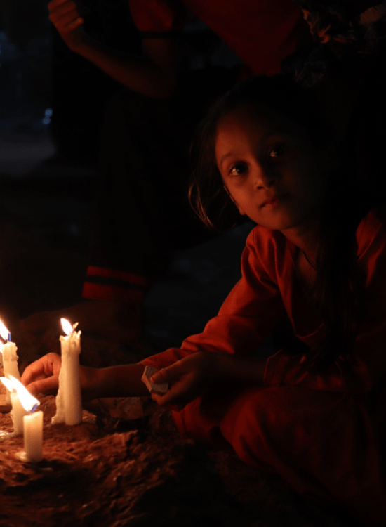 Indian girl sitting by candles in the dark